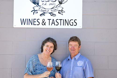 Lowel and Anne Jooste posing together under their signage 